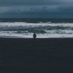 A lone person on a dark beach